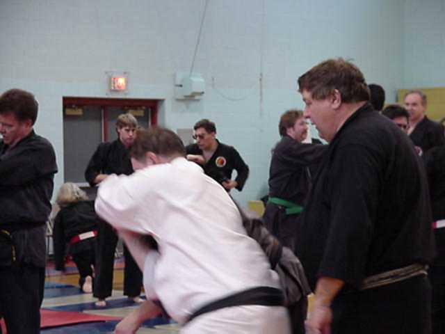 Hanshi Cavalier watches Hugh perform an Aiki takedown